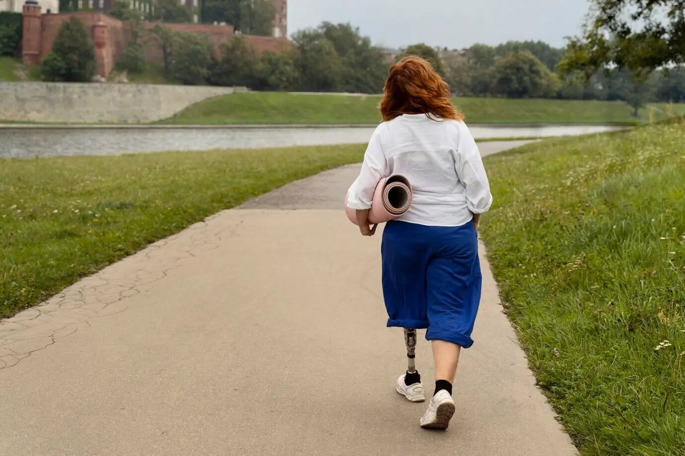 Женщина с протезом ноги занимается йогой.